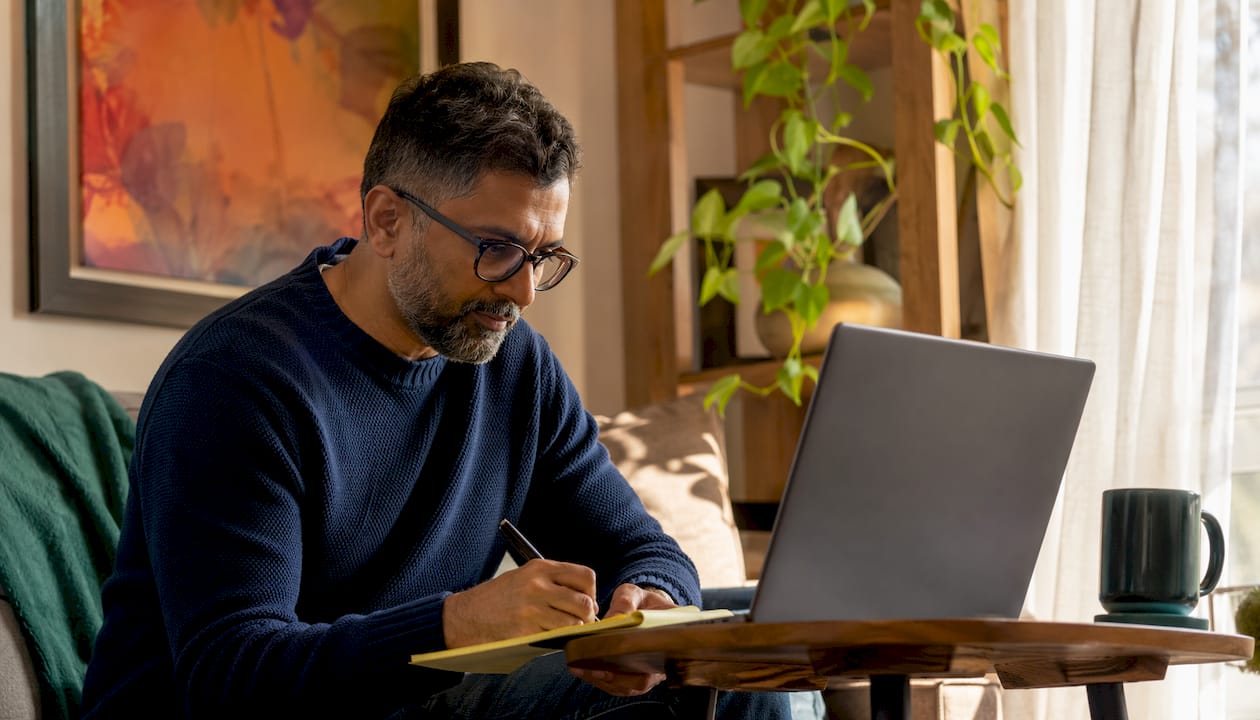 Man engaged in virtual volunteering at kitchen table